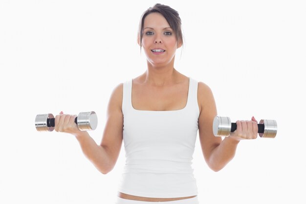 Portrait of young woman exercising with dumbbells