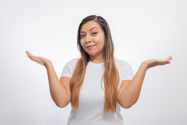 Portrait of young woman expressing question with her arms Woman expressing indecision