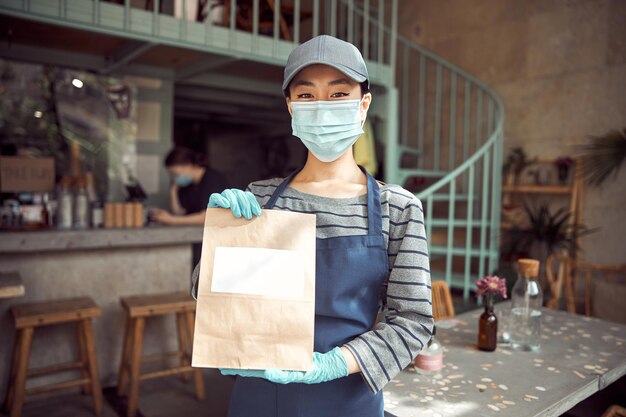 Portrait of young woman in face mask working indoors