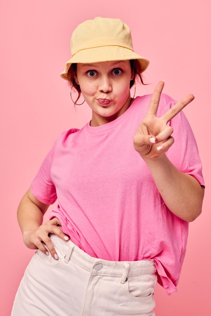 Photo 若い女性の肖像画ファッション服帽子ピンクのtシャツの装飾ポーズ