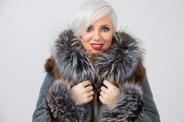 Portrait of young woman in fashionable jacket with fur isolated