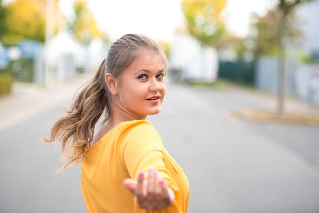 Foto ritratto di una giovane donna che fa gesti mentre cammina per strada