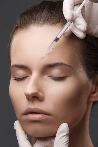 Portrait of young woman getting cosmetic injection