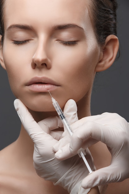 Portrait of young woman getting cosmetic injection