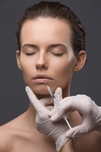 Portrait of young woman getting cosmetic injection