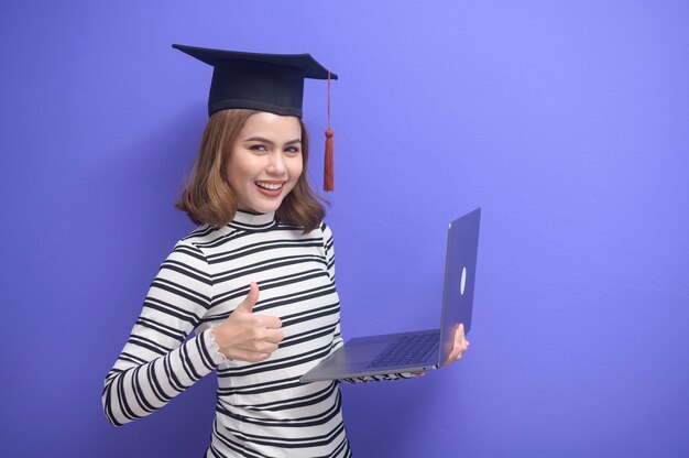 A portrait of young woman graduated over blue background