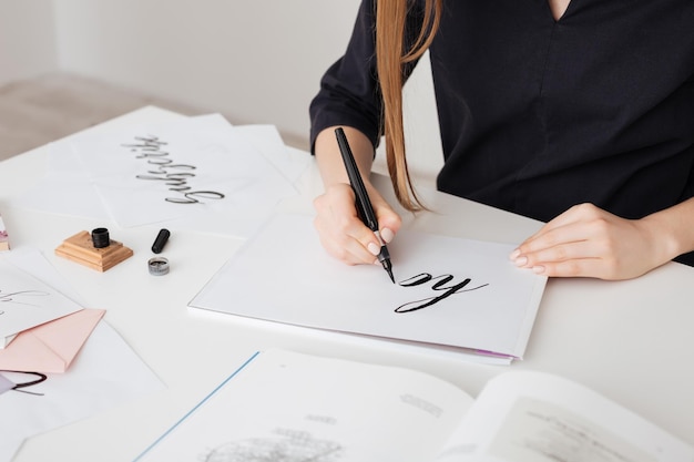 Portrait of young woman hands writing beautiful notes on paper on desk isolated