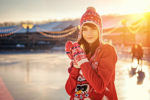 Portrait of a young woman in a hat on the ice rink