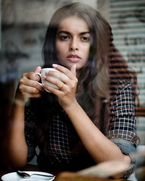 Photo portrait of young woman having drink at restaurant