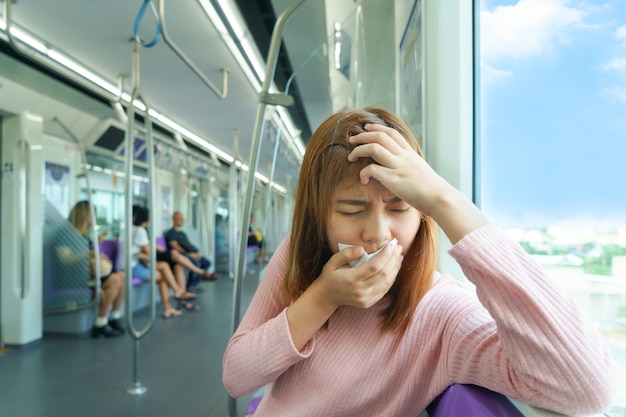 Foto ritratto dell'emicrania o del malumore della giovane donna mentre prendendo lo sky train.