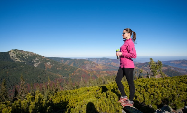 Portrait of young woman hiker with cup of tea