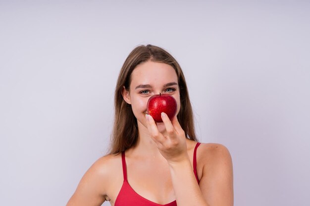 Foto ritratto di una giovane donna con una mela sullo sfondo bianco