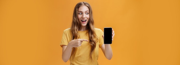 Photo portrait of young woman holding book against yellow background