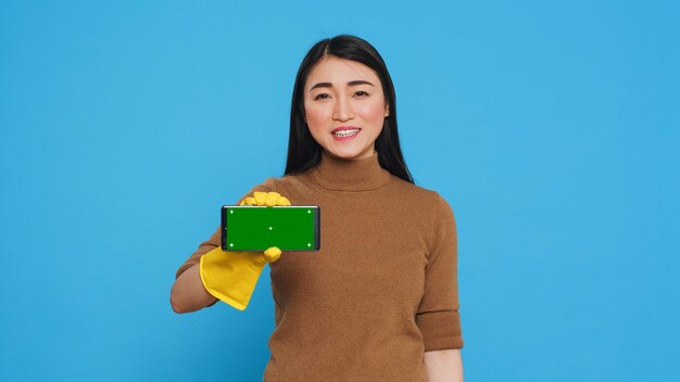 Portrait of young woman holding box against blue background