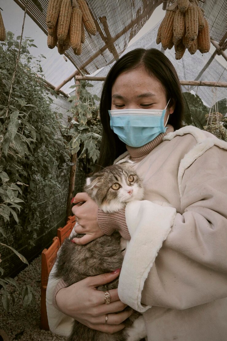 Photo 고양이를 들고 있는 젊은 여성의 초상화