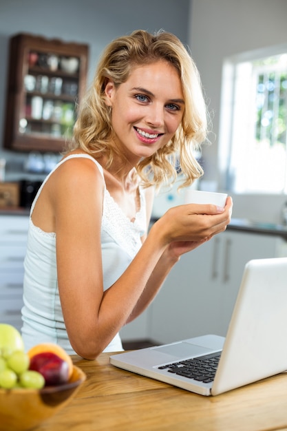 Portrait of young woman holding coffee cup