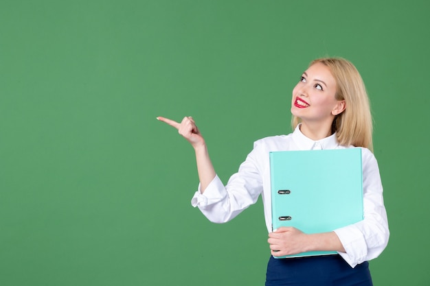 portrait of young woman holding document green wall school lesson teacher students