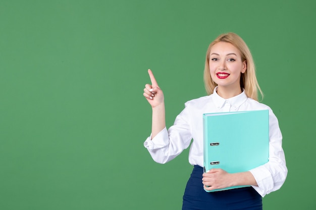 portrait of young woman holding document green wall student teacher school lessons