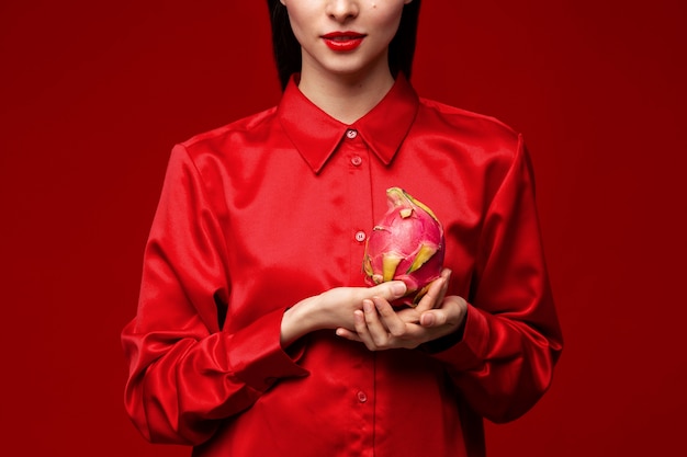 Foto ritratto di giovane donna che tiene la frutta del drago