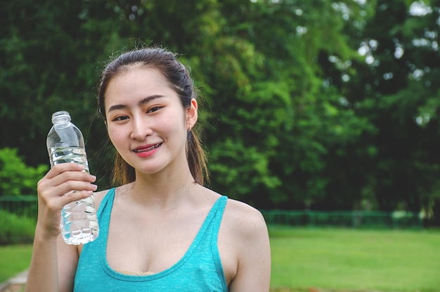 飲み物のボトルを握っている若い女性の肖像画