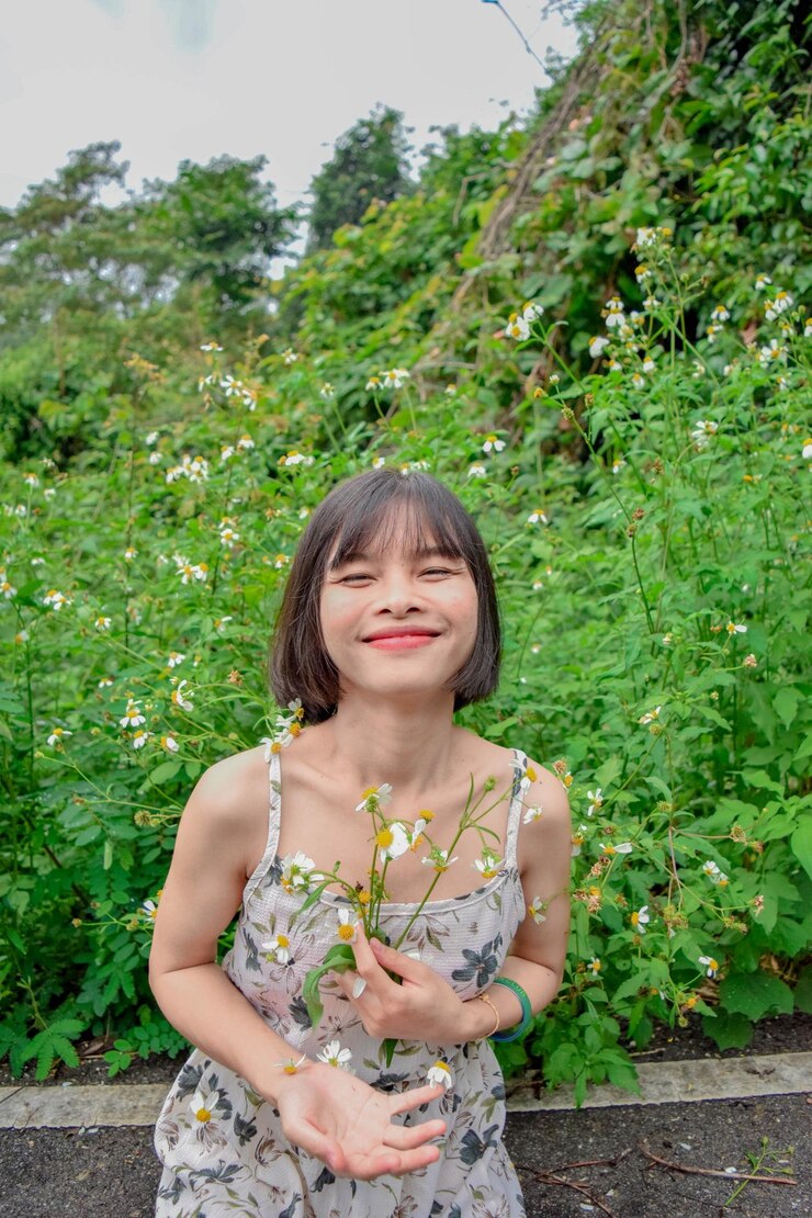 Photo 站在樹上拿著花的年輕女人的肖像