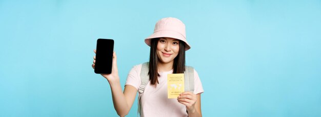 Portrait of young woman holding gift against blue background