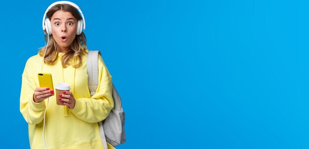 Photo portrait of young woman holding gift against blue background