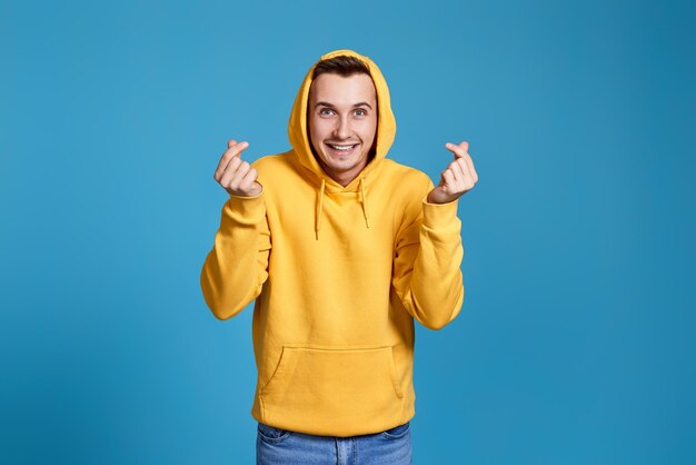 Portrait of young woman holding gift against blue background