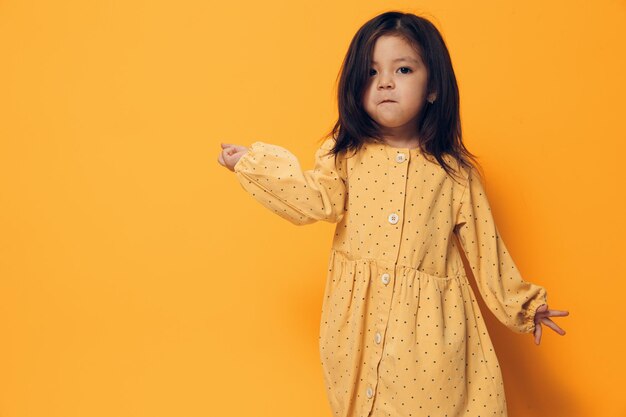 Portrait of young woman holding gift against yellow background