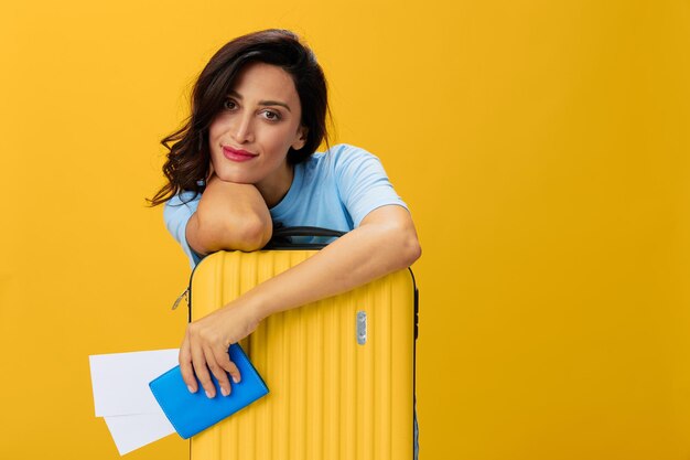 Portrait of young woman holding gift box against yellow background