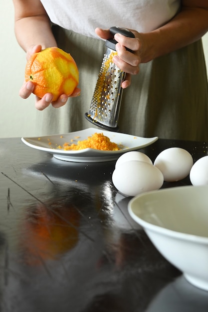 Portrait of young woman holding grated orange