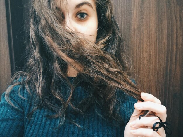 Foto ritratto di una giovane donna che tiene i capelli