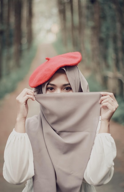 Portrait of young woman holding hat
