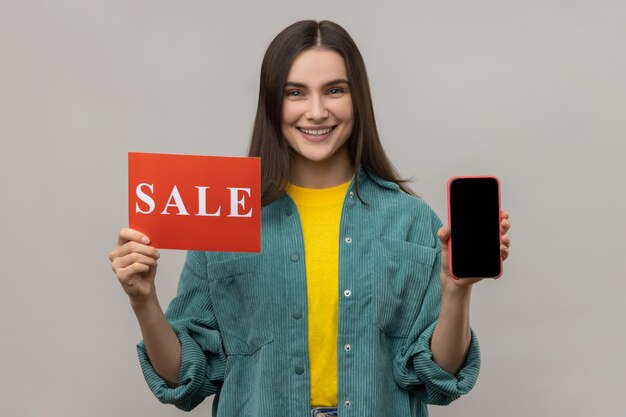 Foto ritratto di una giovane donna con un telefono cellulare su sfondo bianco