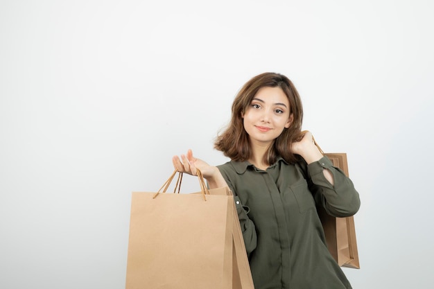 幸せな表情でペーパークラフトバッグを保持している若い女性の肖像画。高品質の写真