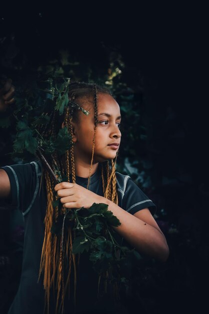 Foto ritratto di una giovane donna che tiene una pianta