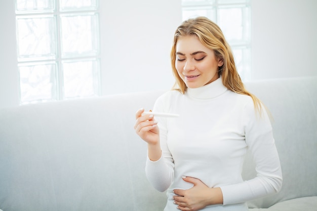 Portrait young woman holding pregnancy test stick