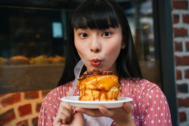 外で甘い食べ物を持った若い女性の肖像画