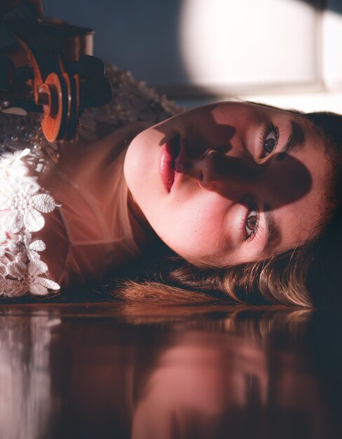 Photo portrait of young woman holding violin while lying down at home