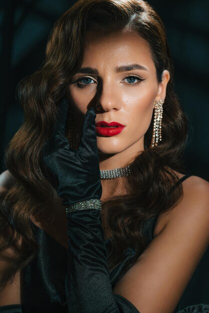 Portrait of young woman in Hollywood retro noir style A beautiful brunette girl with a hairstyle and makeup with jewelry in classic vintage look