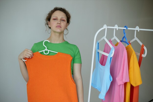 Portrait of a young woman ironing clothes on a hanger wardrobe cropped view unaltered person