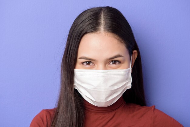 Portrait of A young woman is wearing face mask on purple background