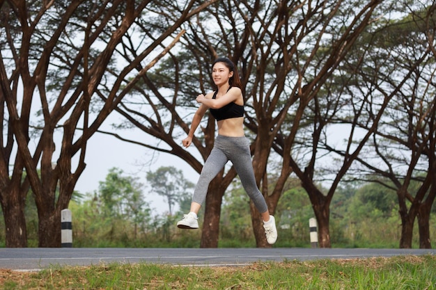 Portrait of young woman jumping in park