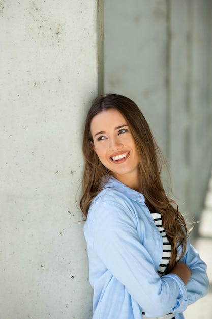 Portrait of a young woman leaning on a wall