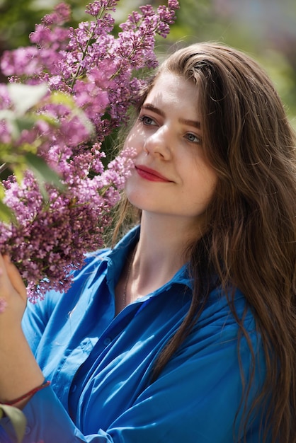 Portrait of a young woman in lilac flowers