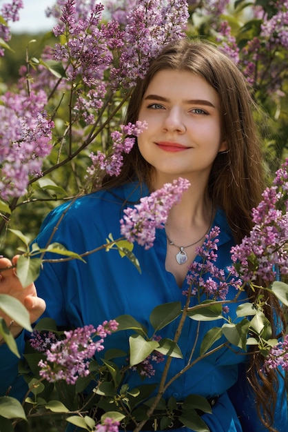 Portrait of a young woman in lilac flowers