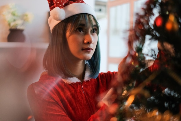 クリスマスツリーを眺める若い女性の肖像画