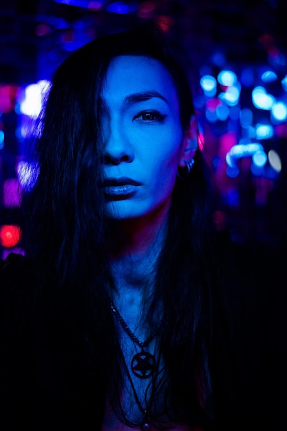 Photo portrait of young woman looking away at night