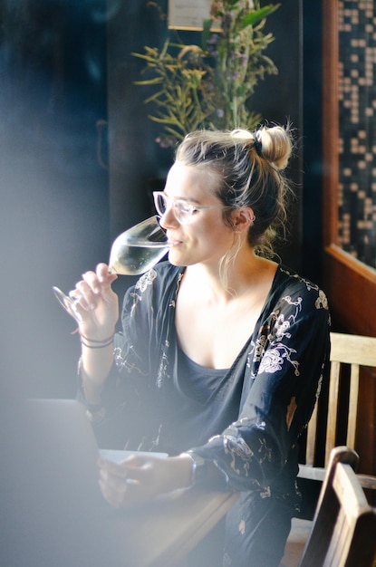 Portrait of young woman looking away while sitting on table