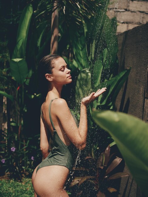 Photo portrait of young woman looking away while standing against plants